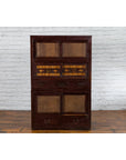 Brown wood Tansu cabinet with metal handles, sliding doors, and drawers, early 20th century Japanese furniture.