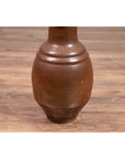 Brown glazed ceramic Tamba Tachikui ware water jug with narrow neck on a wooden floor, 19th century Japanese pottery.