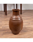 Brown glazed ceramic Tamba Tachikui ware water jug on wooden floor beside a thin-legged table, 19th century Japan.