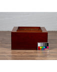Brown Keyaki wood rectangular hibachi with copper liner next to a color calibration chart, close-up.