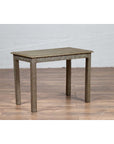 Silver overlay metal Indian vintage coffee table on wooden floor next to a white brick wall, mid-century style setting.