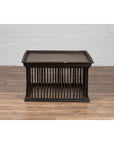 Square rattan coffee table with silver leaf top and spindle design on wood floor against a white wall.