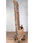 Side view of large natural wood bonnet top window balcony with hand-carved foliage motifs on wooden floor.