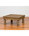 Brass geometric window grate coffee table on hardwood floor, antique Indian style design, full view.