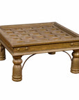 Brass geometric window grate repurposed as coffee table, antique-inspired design, shown as tabletop furniture.