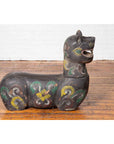 Polychrome wood guardian animal carving with floral patterns, Northern Thai antique, displayed on wooden floor.
