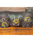 Close-up of a carved and polychrome mythical guardian animal from Northern Thailand, antique wood, on a wooden floor.
