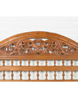 Brown carved wood Indonesian headboard with scrolling foliage, arched top, and petite balusters, front view.
