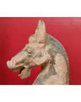 Terracotta Chinese Han Dynasty horse, large, displayed against a solid red background.