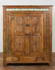 Brown wood Indonesian cabinet with carved sunburst designs and blue tile accents on wooden floor, 19th century.