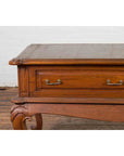 Close-up of a brown wooden Dutch Colonial low table, early 20th century, with two drawers and cabriole legs.