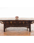 Two-toned Shiva Lingam stone from Narmada River on dark carved wooden antique table, close-up view.