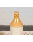 Yellow and cream ceramic Chinese flask, vintage style, displayed on a patterned surface.