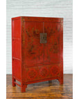 Red lacquer wood Qing Dynasty cabinet with gilded chinoiserie décor, set against a white brick wall and wood floor.