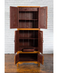 Brown wooden Qing Dynasty Chinese cabinet with Chinoiserie panels, open doors, shelves, and drawer on wood floor.
