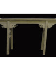 Vintage wooden altar table with splayed legs and carved apron, displayed against a solid black background.