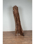 Brown driftwood carving sculpture on wooden floor, Northern Thailand style decor, indoor setting.