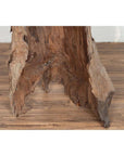 Brown driftwood carving, wood sculpture from Northern Thailand, displayed against a white brick wall indoors.