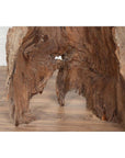 Brown driftwood carving, wood material, indoors on wooden floor with light wall background.
