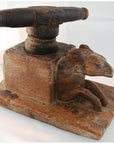 Close-up of vintage hand-carved wood noodle maker with animal figure, possibly a goat, on one side.