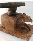 Close-up of vintage hand-carved wood noodle maker with animal figure, possibly a goat, on one side.
