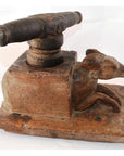 Close-up of hand-carved wooden noodle maker presses with carved animal figures, folk art style, on tabletop.