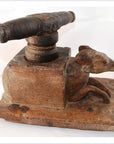 Close-up of hand-carved wooden noodle maker presses with carved animal figures, folk art style, on tabletop.