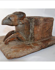 Weathered wood animal noodle maker with ram's head and legs, antique style, close-up on flat base.