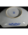 Blue and white porcelain bowl upside down, hand painted with floral design and maker’s mark on black background.