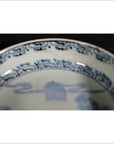 Close-up of blue and white porcelain bowl rim with intricate hand painted Asian patterns.
