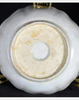 Close-up of underside of antique Asian hand painted porcelain bowl with circular foot ring on gold stand.