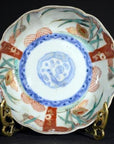Close-up of an antique porcelain bowl with floral and geometric motifs on an ornate brass stand.