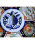 Close-up of multicolored hand painted porcelain bowl with floral designs and blue, red, green, and gold patterns.