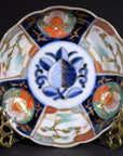 Blue, red, and gold hand painted porcelain bowl on metal stand, antique Asian style, close-up view.