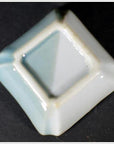 Blue and white porcelain square dish with ombré glaze and raised edges, antique Asian hand-painted design, close-up.