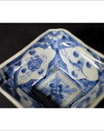 Close-up of an antique porcelain bowl with hand-painted floral and geometric patterns on the inner surface.