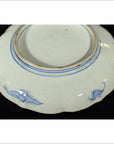 White porcelain plate bottom with hand-painted prancing goats design, shown on a black background.