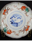 Blue and white porcelain plate with prancing goats around rim and blue floral landscape design in the center.