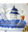 Close-up of blue, gold, and red hand-painted antique Asian porcelain plate with pagoda island design and seal mark.