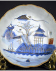 White porcelain plate with hand painted Pagoda Island scene, red seal mark, on decorative stand.