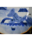 White porcelain plate with Misty Peaks and Arched Bridge design, abstract scene, scalloped rim, close-up view.