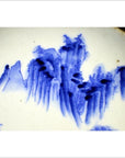 White porcelain plate with hand-painted mountain landscape and willow trees in traditional Asian style, close-up view.