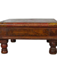 Rustic brown wooden Asian prayer table or coffee table with thick legs and rectangular top, close-up view.