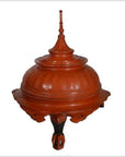 Close-up of antique 19th-century Burmese red carved wood offering basket with pointed lid and ornate base.