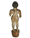 Weathered wooden statue of a standing figure with bent arms on a rounded base, antique Burmese temple carving.