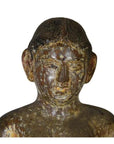 Close-up of an antique wooden Burmese temple carving, showing a serene, large-eared human figure.
