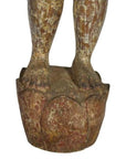 Close-up of weathered red-brown wood Burmese temple carving feet on detailed lotus base with aged patina.