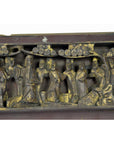 Close-up of antique Chinese wooden temple plaque with gold accents, robed figures, and rounded tree foliage.
