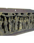 Wooden and gold antique Chinese temple plaque with carved figures in traditional dress beneath trees, angled view.