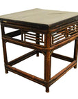 Brown bamboo side table with lacquered finish, black stone top, and slatted panels against white background.